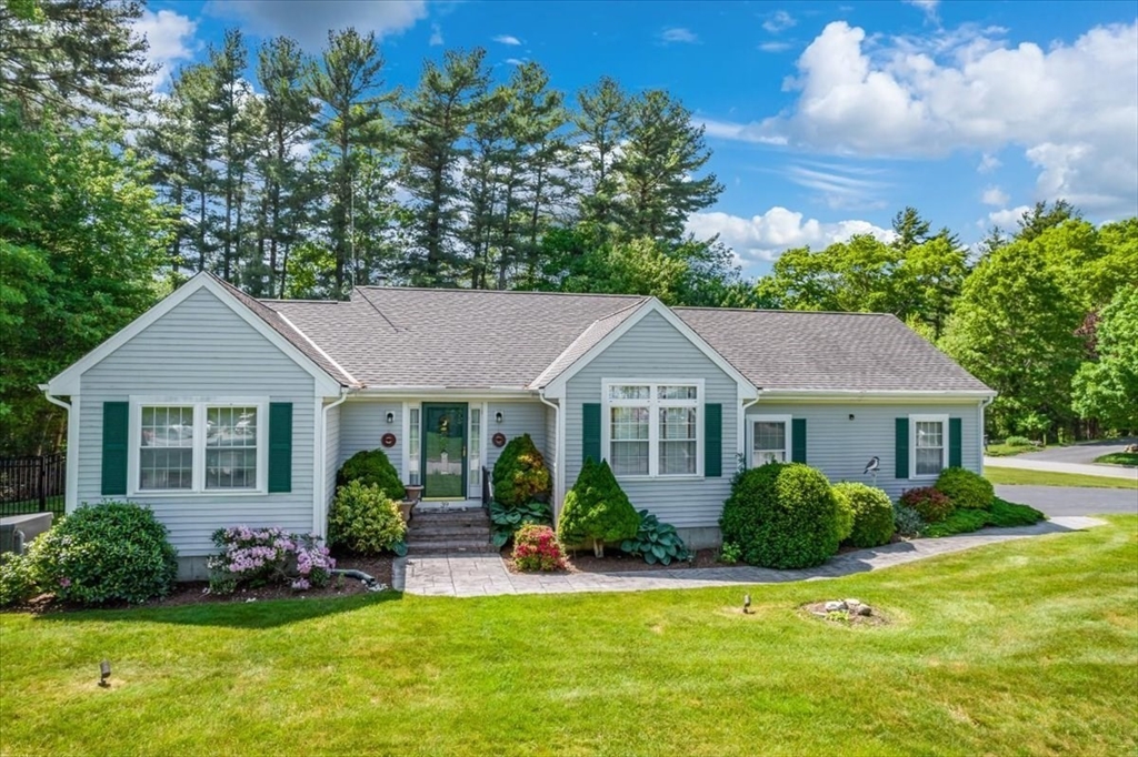 a front view of a house with a yard and potted plants