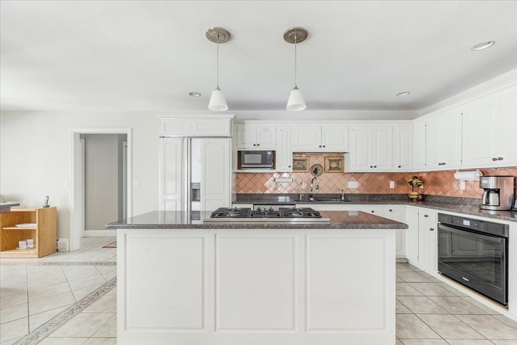 39 Waterfall Road Acushnet, MA 02743 - Photo 8 of 32 a kitchen with kitchen island granite countertop a stove a sink and white cabinets