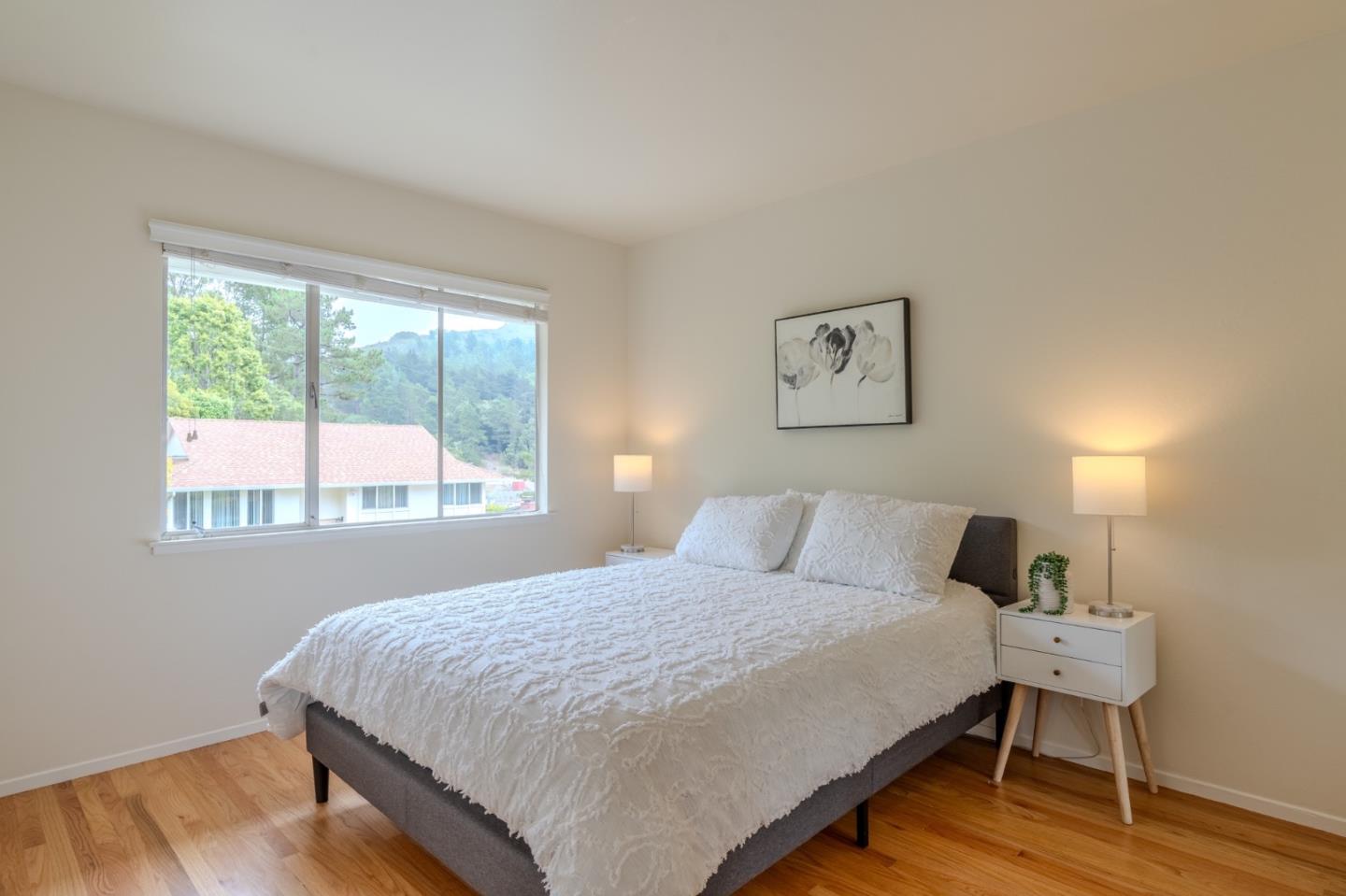 1031 Yosemite Drive Pacifica, CA 94044 - Photo 20 of 40 a bedroom with a bed and wooden floor