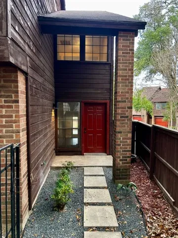 a front view of a house with glass windows and a yard