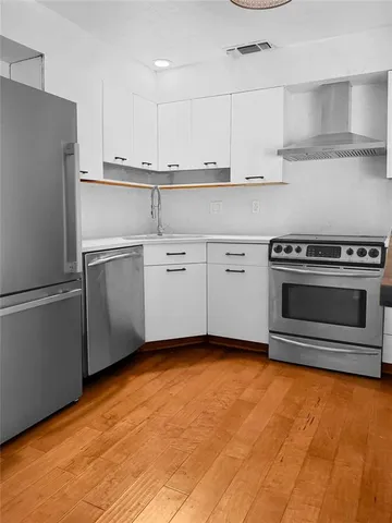 a kitchen with stainless steel appliances granite countertop a refrigerator sink and stove