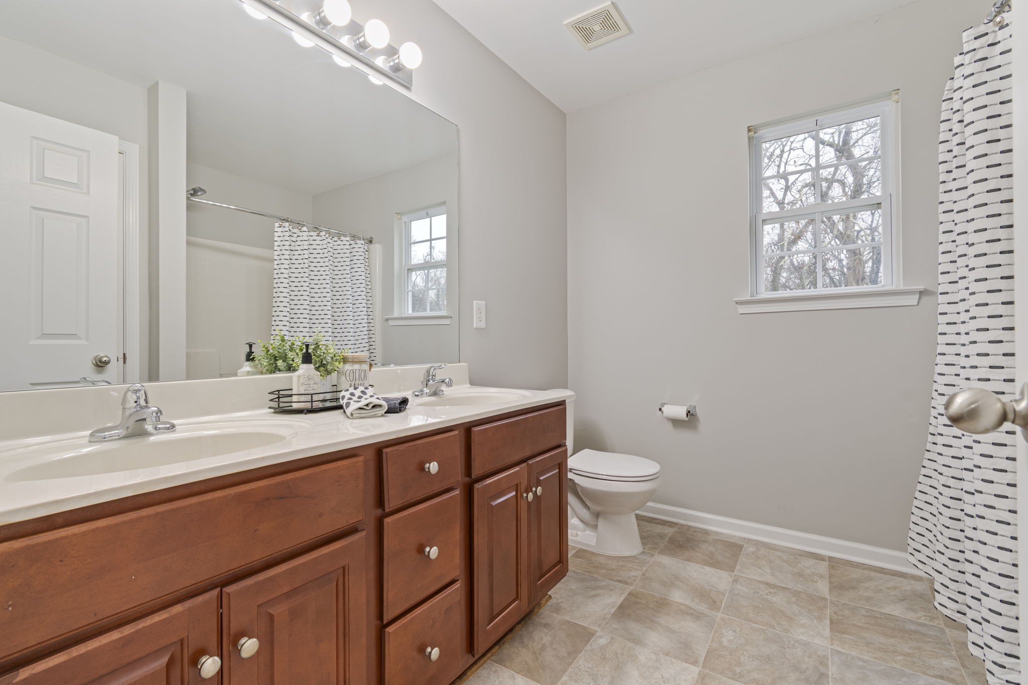 1112 Golf View Way Spring Hill, TN 37174 - Photo 28 of 47 a bathroom with a double vanity sink toilet and a mirror