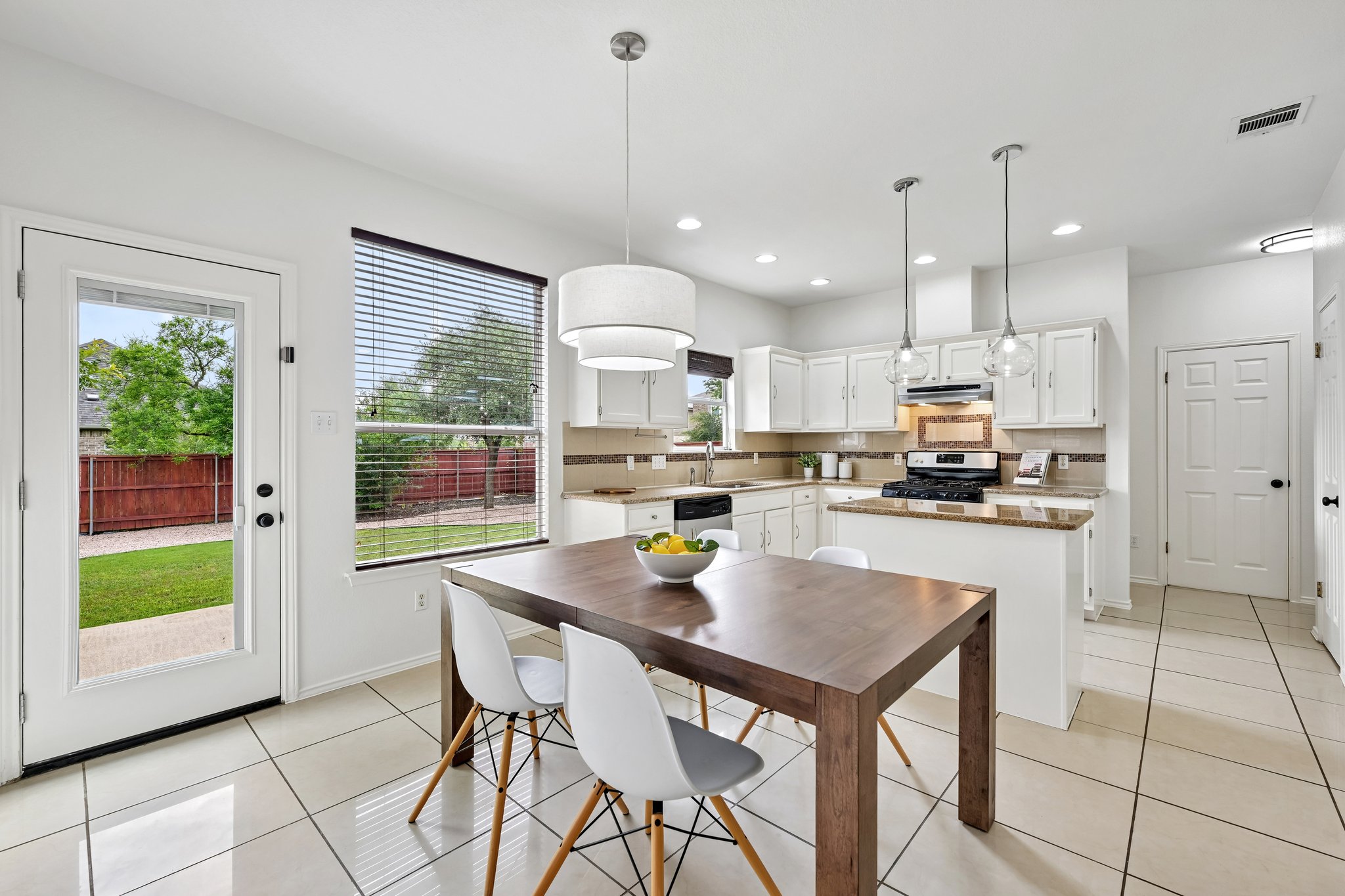 4100 Mocha Trail Austin, TX 78728 - Photo 8 of 33 A well-lit kitchen with sleek tile flooring and a view to the backyard offers a bright dining space.