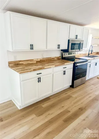 a kitchen with granite countertop a sink a stove and cabinets
