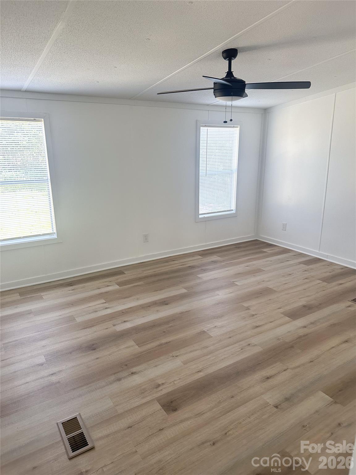 2976 Stephens Road Bethune, SC 29009 - Photo 16 of 24 an empty room with wooden floor cabinet and windows