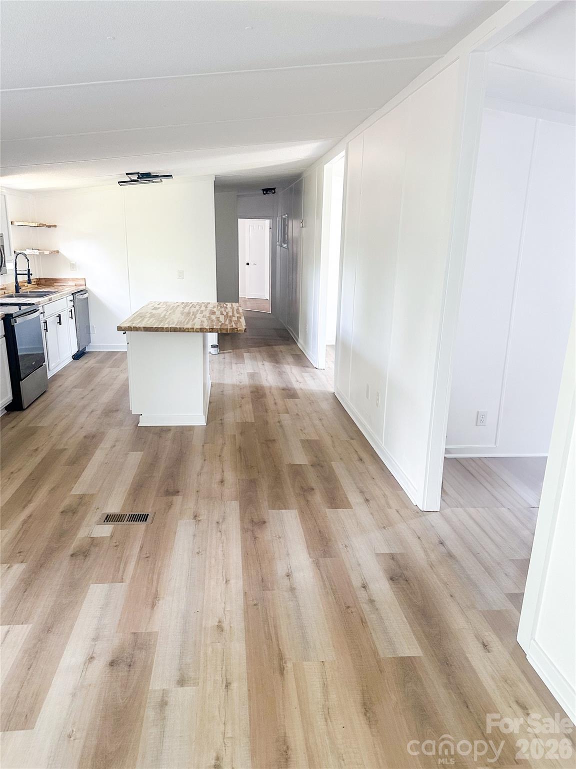 2976 Stephens Road Bethune, SC 29009 - Photo 8 of 24 a view of a kitchen with kitchen island a sink wooden floor and living room view