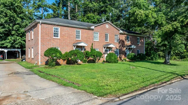 a front view of a house with a yard and trees