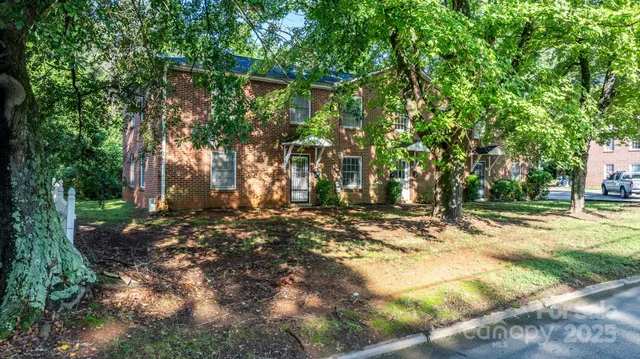 a view of a yard with plants and trees