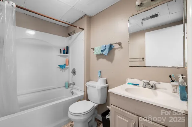 a bathroom with a granite countertop sink a toilet and shower