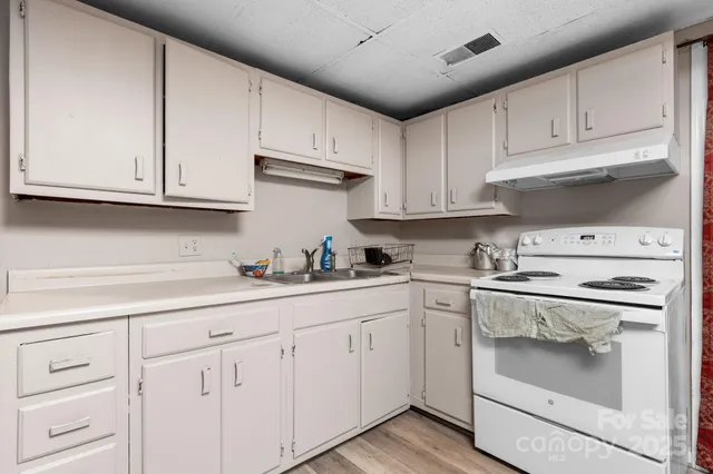 a kitchen with granite countertop white cabinets and white appliances