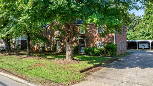 a view of a yard with plants and trees