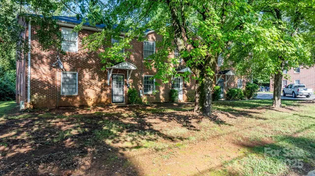a view of a yard with plants and trees