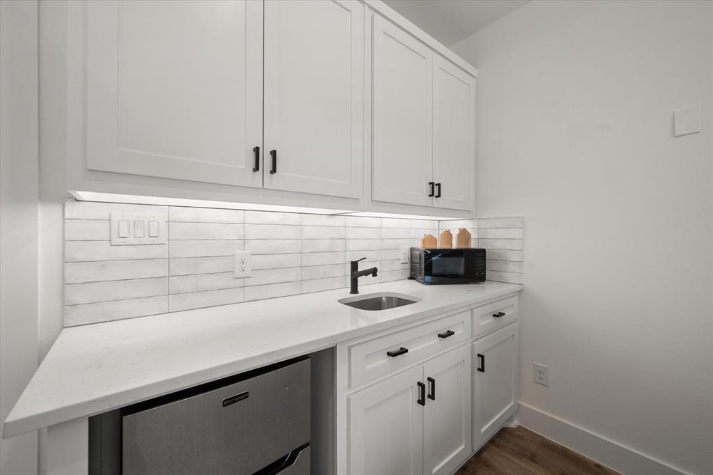 11077 Highway 287, Unit 1 Kerens, TX 75144 - Photo 26 of 40 Bar featuring white cabinetry, light stone counters, backsplash, and black microwave