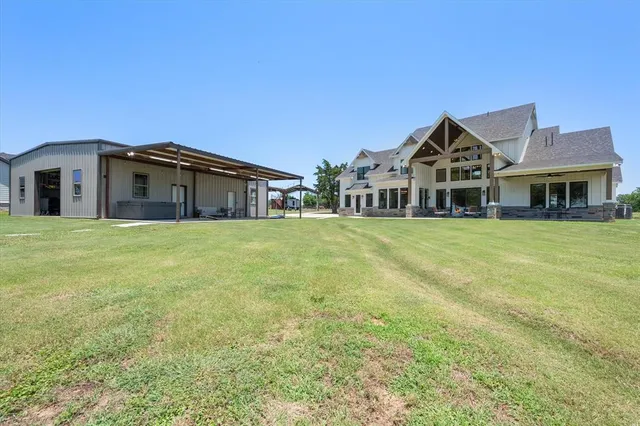 a view of a house with a big yard and large trees