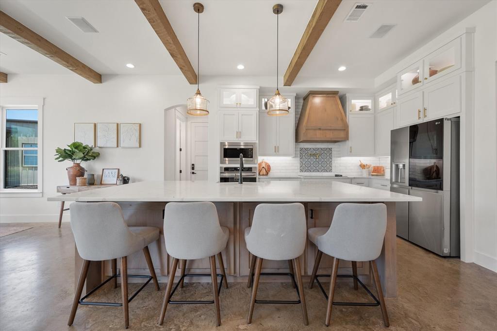 11077 Highway 287, Unit 1 Kerens, TX 75144 - Photo 7 of 40 a kitchen with a table chairs refrigerator and microwave