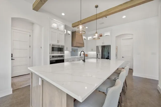 a kitchen with a table chairs refrigerator and microwave