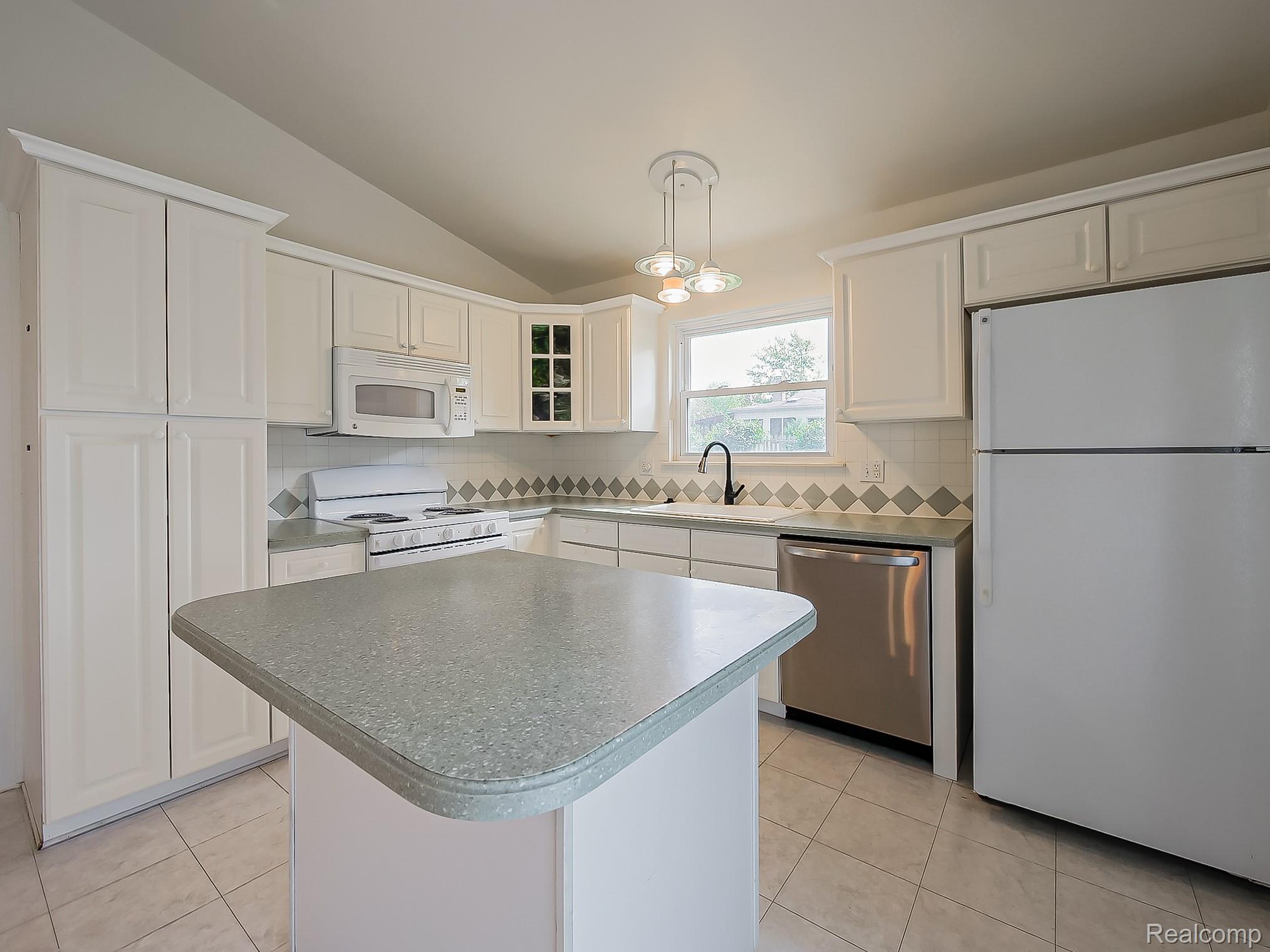 42195 Park Ridge Road Novi, MI 48375 - Photo 4 of 52 Kitchen featuring white cabinetry, a center island with composite countertop, tile backsplash, and stainless steel dishwasher