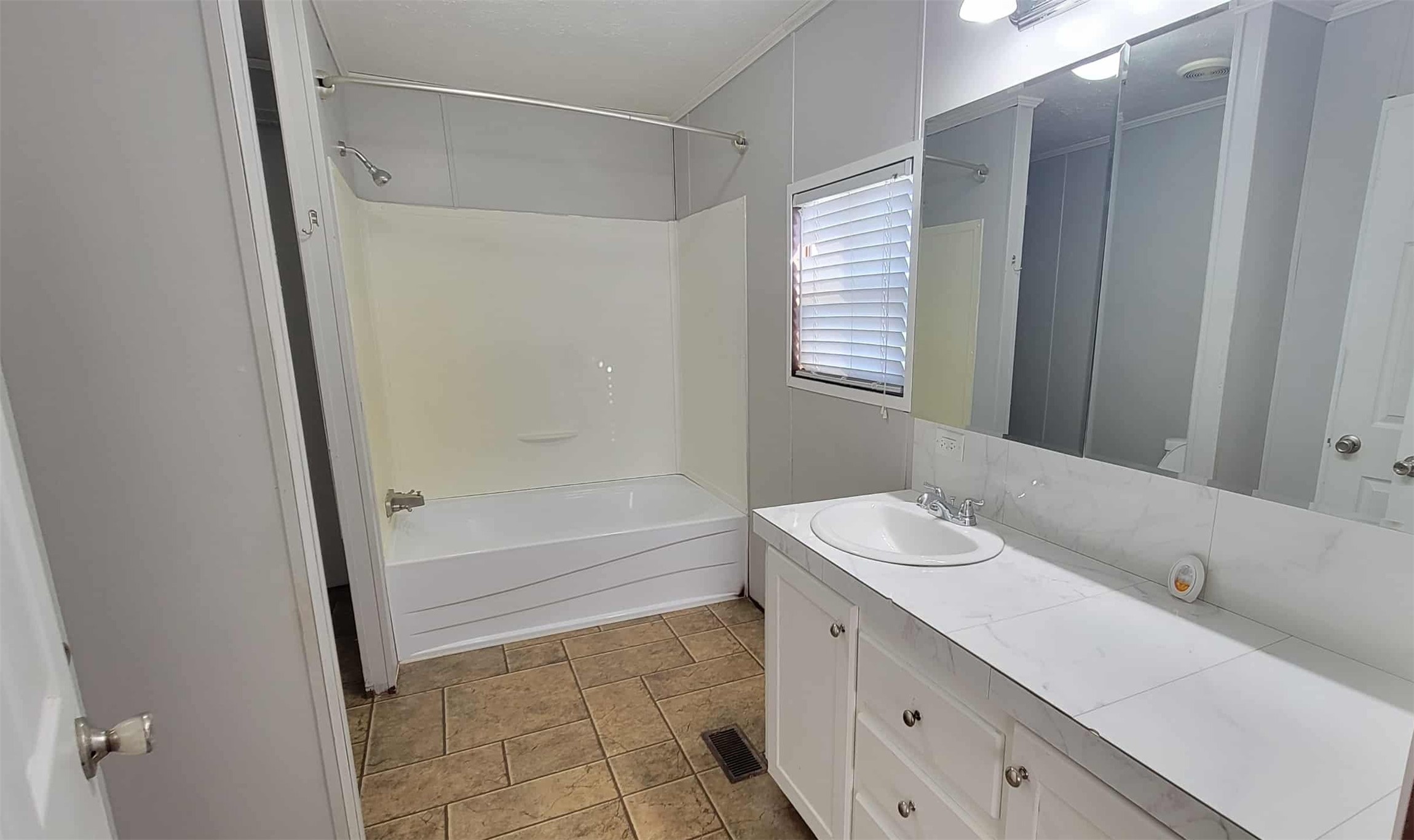 405 Battlebell Road, Unit 2 Highlands, TX 77562 - Photo 11 of 21 a bathroom with a sink a mirror and a bathtub