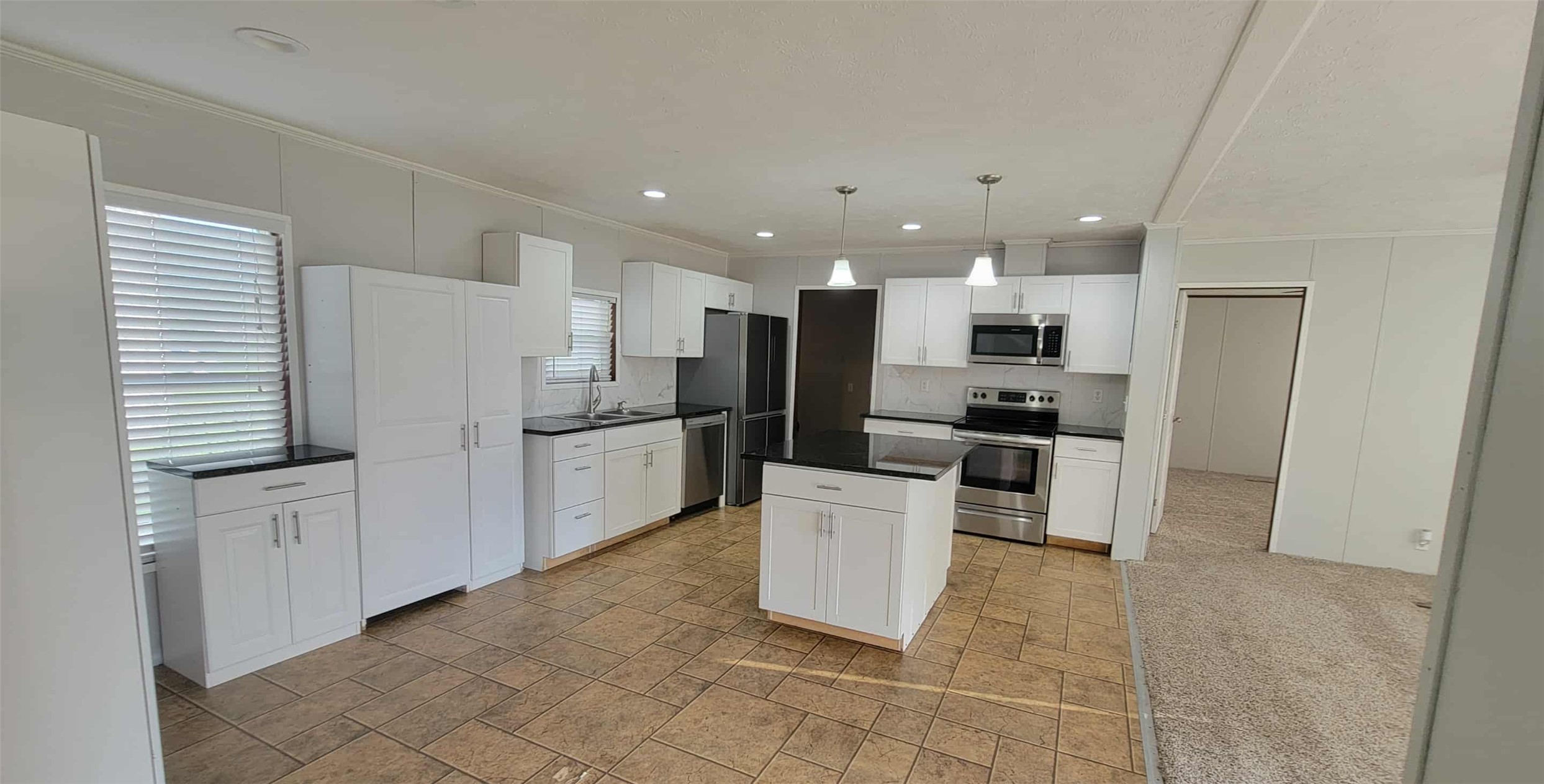 405 Battlebell Road, Unit 2 Highlands, TX 77562 - Photo 4 of 21 a kitchen with white cabinets and stainless steel appliances