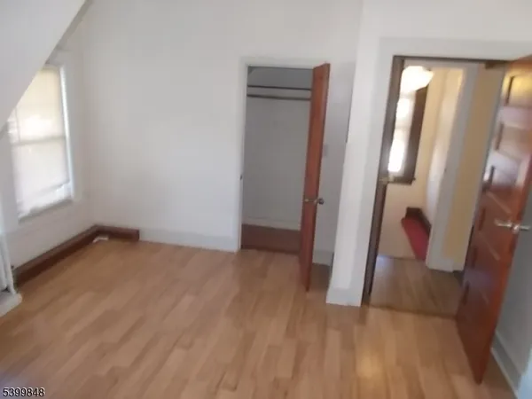an empty room with wooden floor and glass door