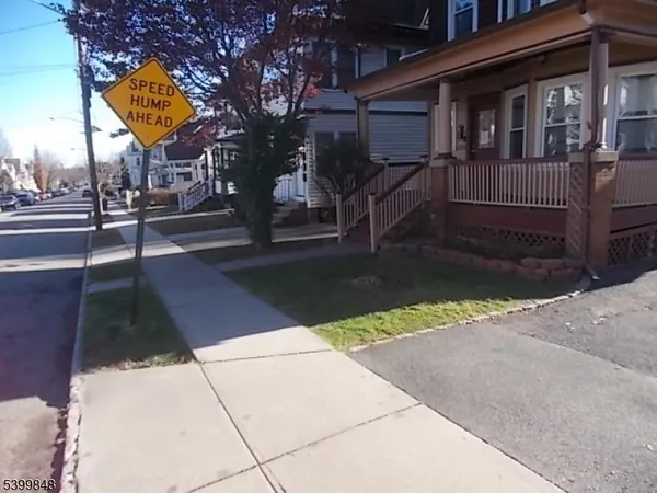 a view of a house with street next to a road