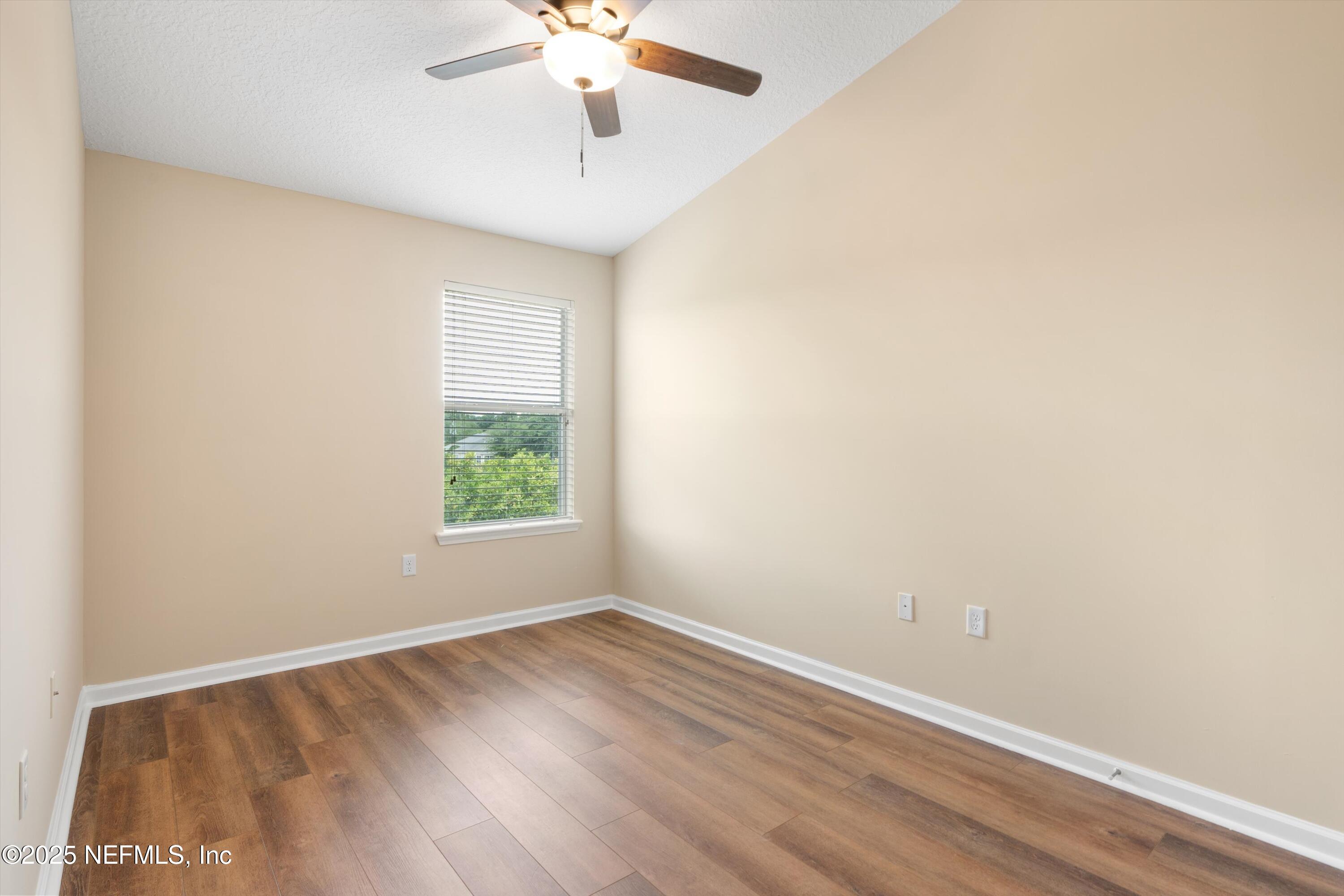 13340 Ocean Mist Drive Jacksonville, FL 32258 - Photo 20 of 25 an empty room with wooden floor and windows