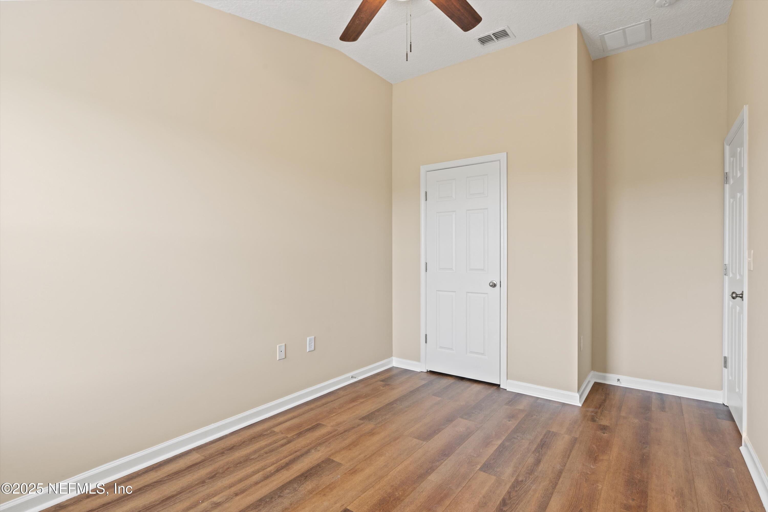 13340 Ocean Mist Drive Jacksonville, FL 32258 - Photo 21 of 25 a view of an empty room with wooden floor and a ceiling fan