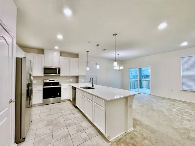a large kitchen with kitchen island a sink stainless steel appliances and cabinets