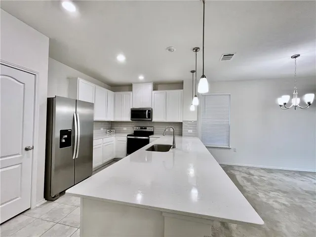 a kitchen with stainless steel appliances a refrigerator sink and microwave