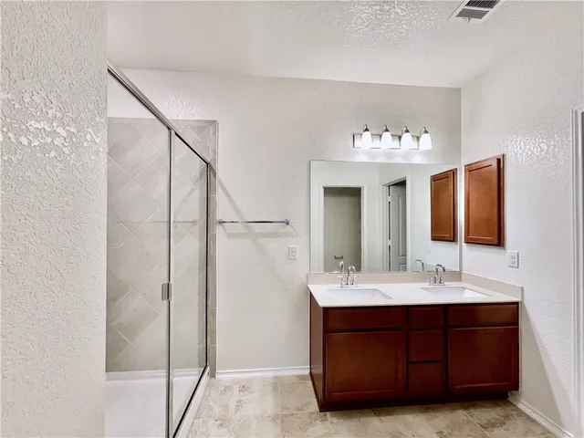 a bathroom with a double vanity sink and mirror