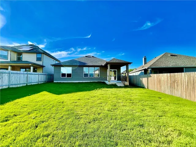 a backyard of a house with table and chairs