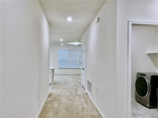 a view of a kitchen with a sink and a washer dryer