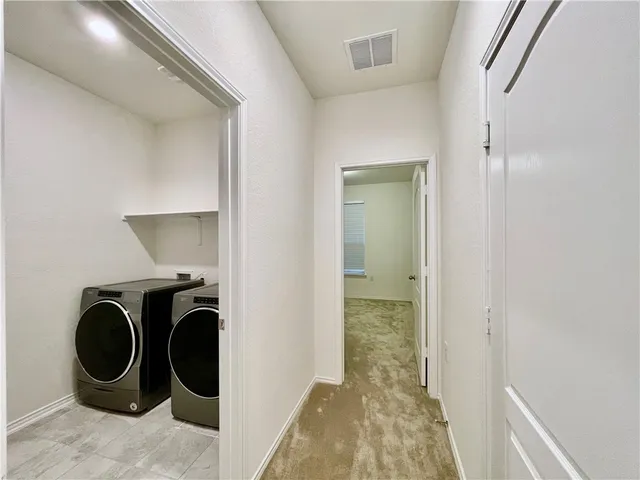 a view of a storage & utility room with dryer and washer