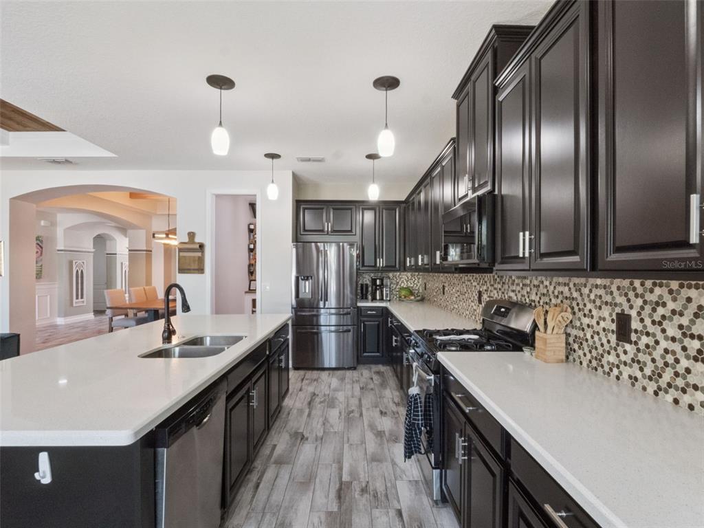 1025 Sadie Ridge Road Clermont, FL 34715 - Photo 12 of 50 a kitchen with stainless steel appliances a sink stove and cabinets