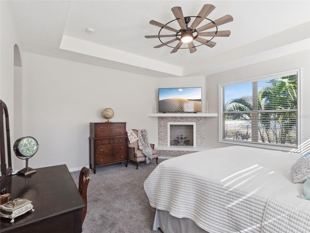 1025 Sadie Ridge Road Clermont, FL 34715 - Photo 22 of 50 a spacious bedroom with a bed and a chandelier