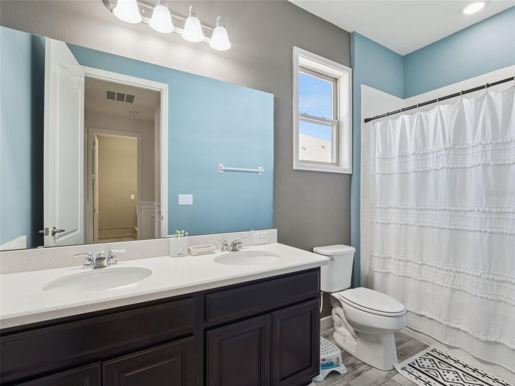 1025 Sadie Ridge Road Clermont, FL 34715 - Photo 30 of 50 a bathroom with a double vanity sink toilet and a mirror