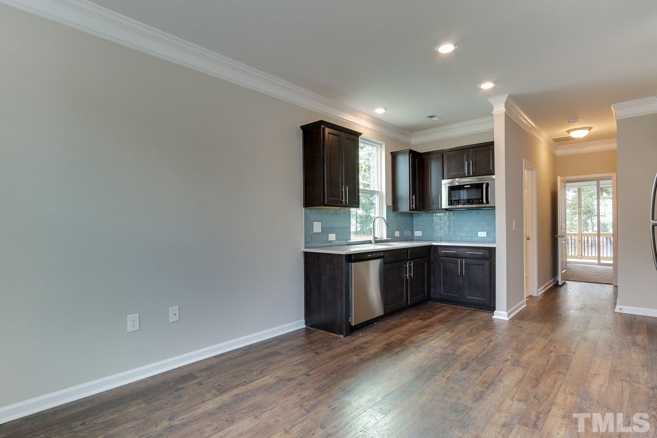 504 Cristobal Street, Unit 134 Rolesville, NC 27571 - Photo 14 of 30 a large kitchen with a sink and dishwasher a stove top oven with wooden floor