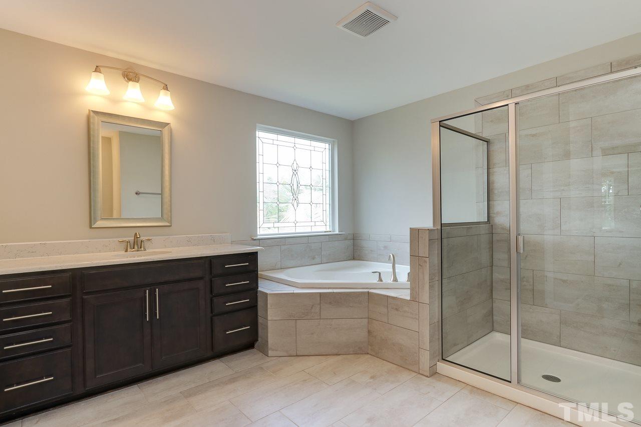504 Cristobal Street, Unit 134 Rolesville, NC 27571 - Photo 21 of 30 a bathroom with a tub sink shower and mirror