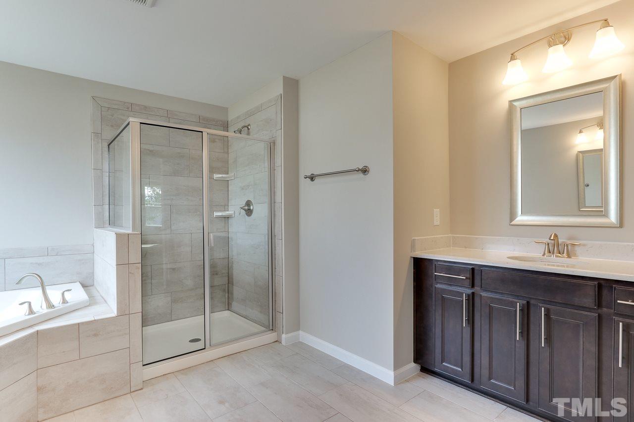 504 Cristobal Street, Unit 134 Rolesville, NC 27571 - Photo 22 of 30 a bathroom with a shower sink and mirror