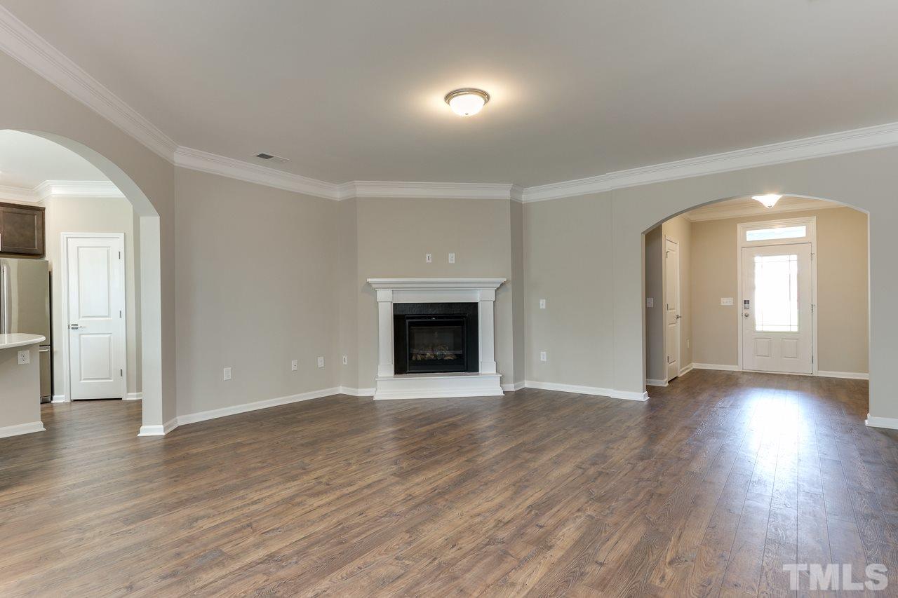 504 Cristobal Street, Unit 134 Rolesville, NC 27571 - Photo 4 of 30 an empty room with wooden floor and a fireplace