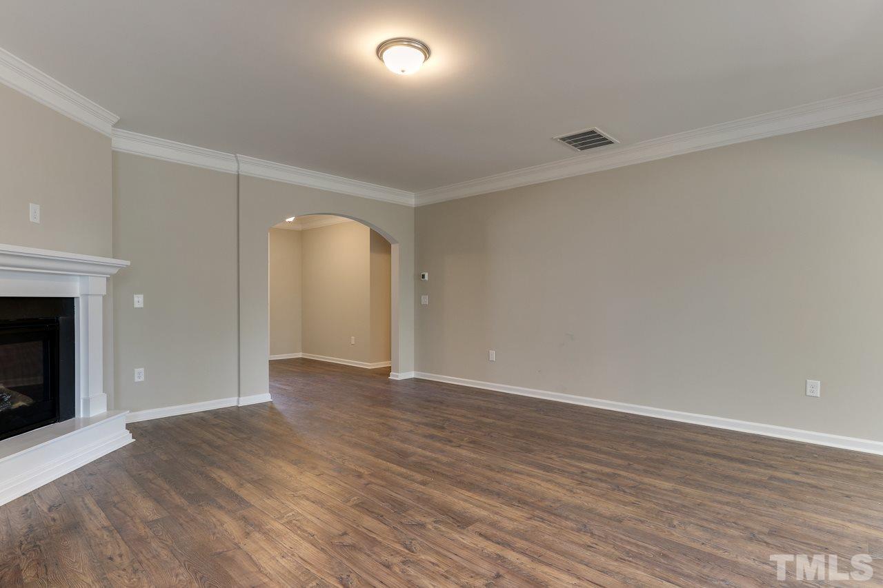 504 Cristobal Street, Unit 134 Rolesville, NC 27571 - Photo 5 of 30 an empty room with wooden floor and fireplace