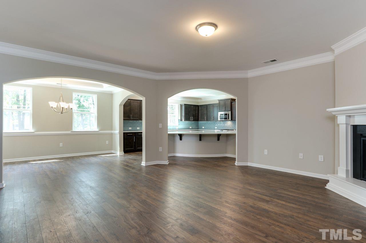 504 Cristobal Street, Unit 134 Rolesville, NC 27571 - Photo 6 of 30 an empty room with wooden floor kitchen view and windows
