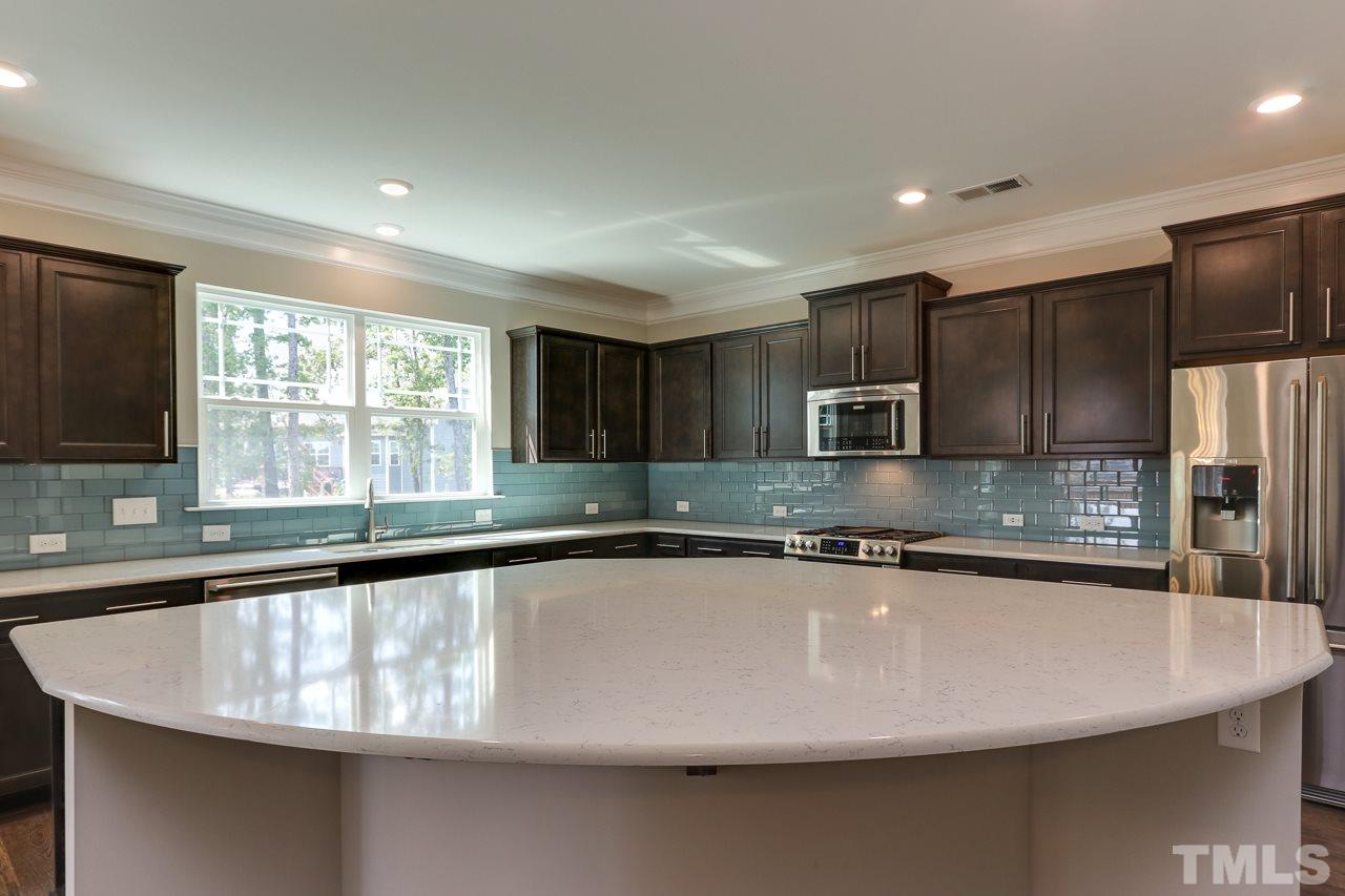 504 Cristobal Street, Unit 134 Rolesville, NC 27571 - Photo 7 of 30 a large kitchen with granite countertop a sink and a counter top space