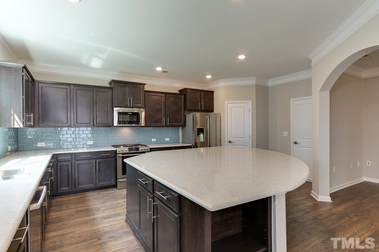 504 Cristobal Street, Unit 134 Rolesville, NC 27571 - Photo 8 of 30 a kitchen with kitchen island a sink stove and refrigerator