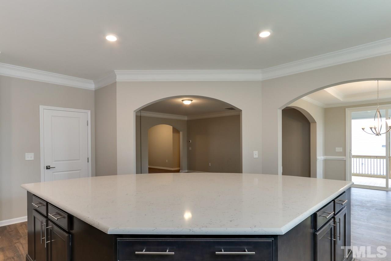 504 Cristobal Street, Unit 134 Rolesville, NC 27571 - Photo 10 of 30 a living room with kitchen island a sink a stove and a refrigerator