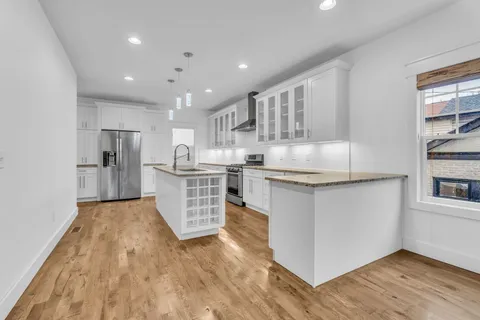 a kitchen with stainless steel appliances granite countertop a refrigerator and a stove top oven