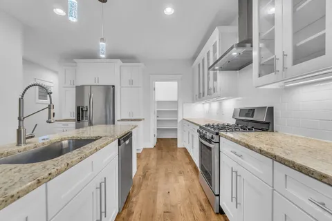 a kitchen with kitchen island granite countertop a sink stainless steel appliances and cabinets