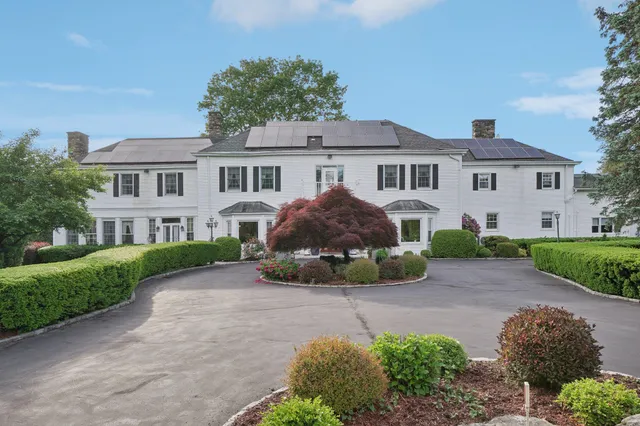 a front view of a house with a garden and yard