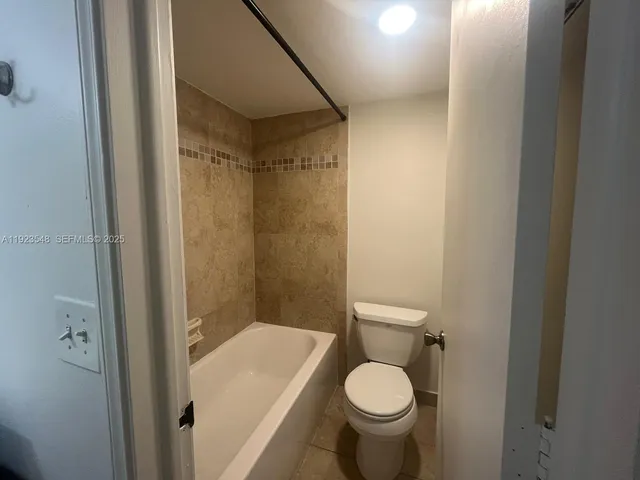 a bathroom with a granite countertop toilet and a sink