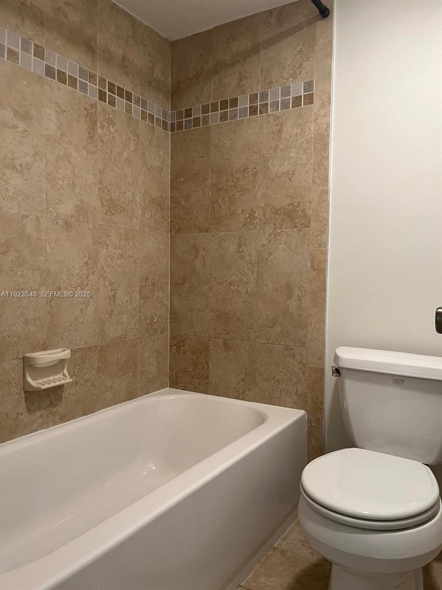 9421 Evergreen Place, Unit 107 Davie, FL 33324 - Photo 14 of 49 a bathroom with a toilet and a bathtub